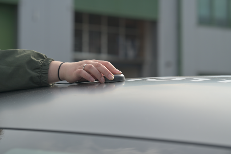 Photograph of the antenna being placed on the roof of a vehicle.