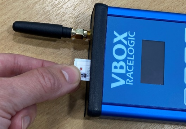 Photograph of a hand inserting the SIM card into NTRIP Modem.
