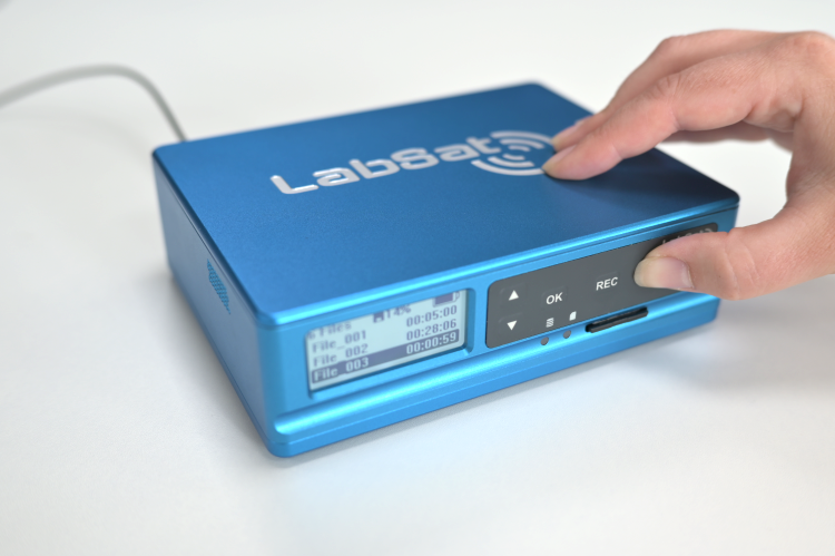 Photograph of a hand pressing the Play button on a LabSat 4.