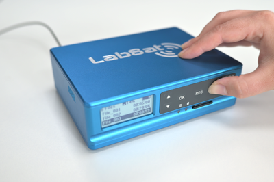 Photograph of a hand pressing the Play button on a LabSat 4.