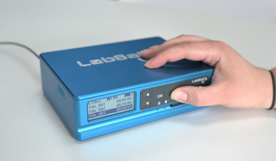 Photograph of a hand pressing the REC button on a LabSat 4.