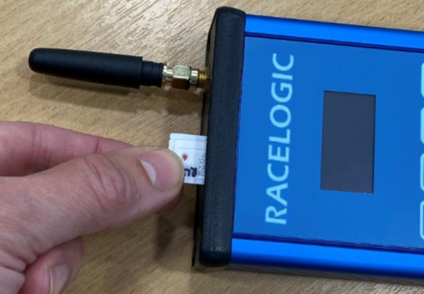 Photograph of a hand inserting a SIM card into VBOX NTRIP Modem.