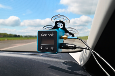 Example installation of a VBOX Mini LapTimer unit mounted on the windscreen inside a car with the GNSS antenna cable and power connection attached.